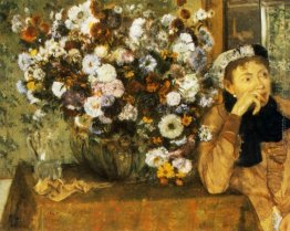 Una donna seduta accanto a un vaso di fiori