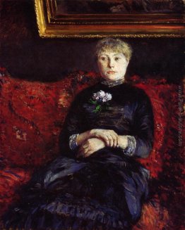 Donna che si siede su un divano rosso a fiori